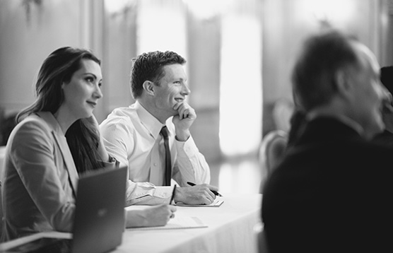 A man and woman sitting at a table with another person.